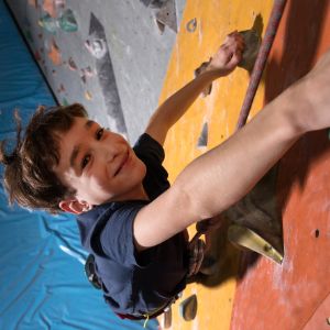 Child smiling as climbing on an indoor wall