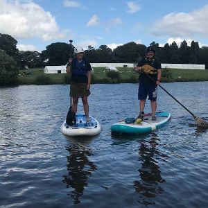 two paddleboarders on the lake at Ripley Castle