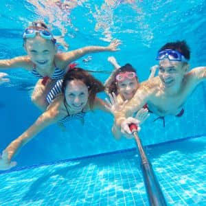 Family underwater in swimming pool with selfie stick
