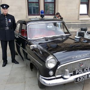 Historic police car and man in historis police uniform