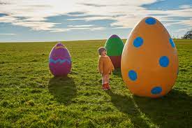 child looking at giant multi-coloured eggs