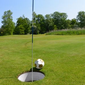 Football next to a footgolf hole on a footgolf course