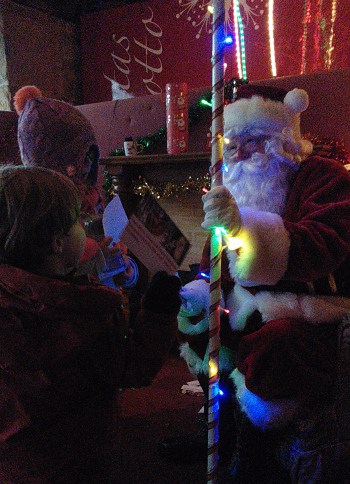 santa in his grotto with two children