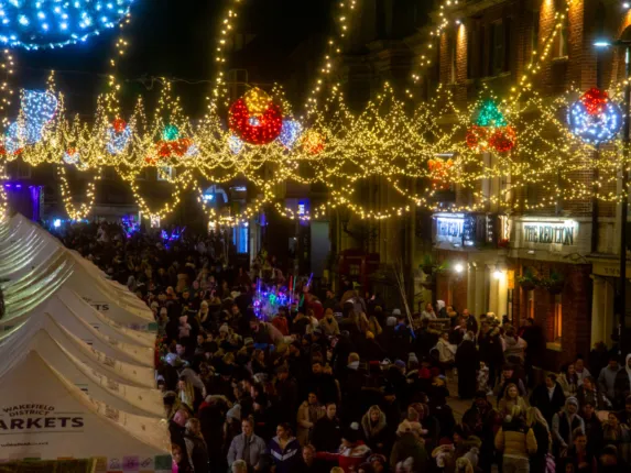 lights across a busy street with people looking at market stalls