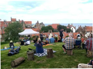 people sitting on camping chairs watching a folk band 