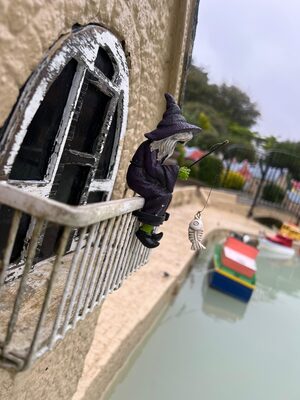 with model sitting on a balcony fishing at Bondville model village