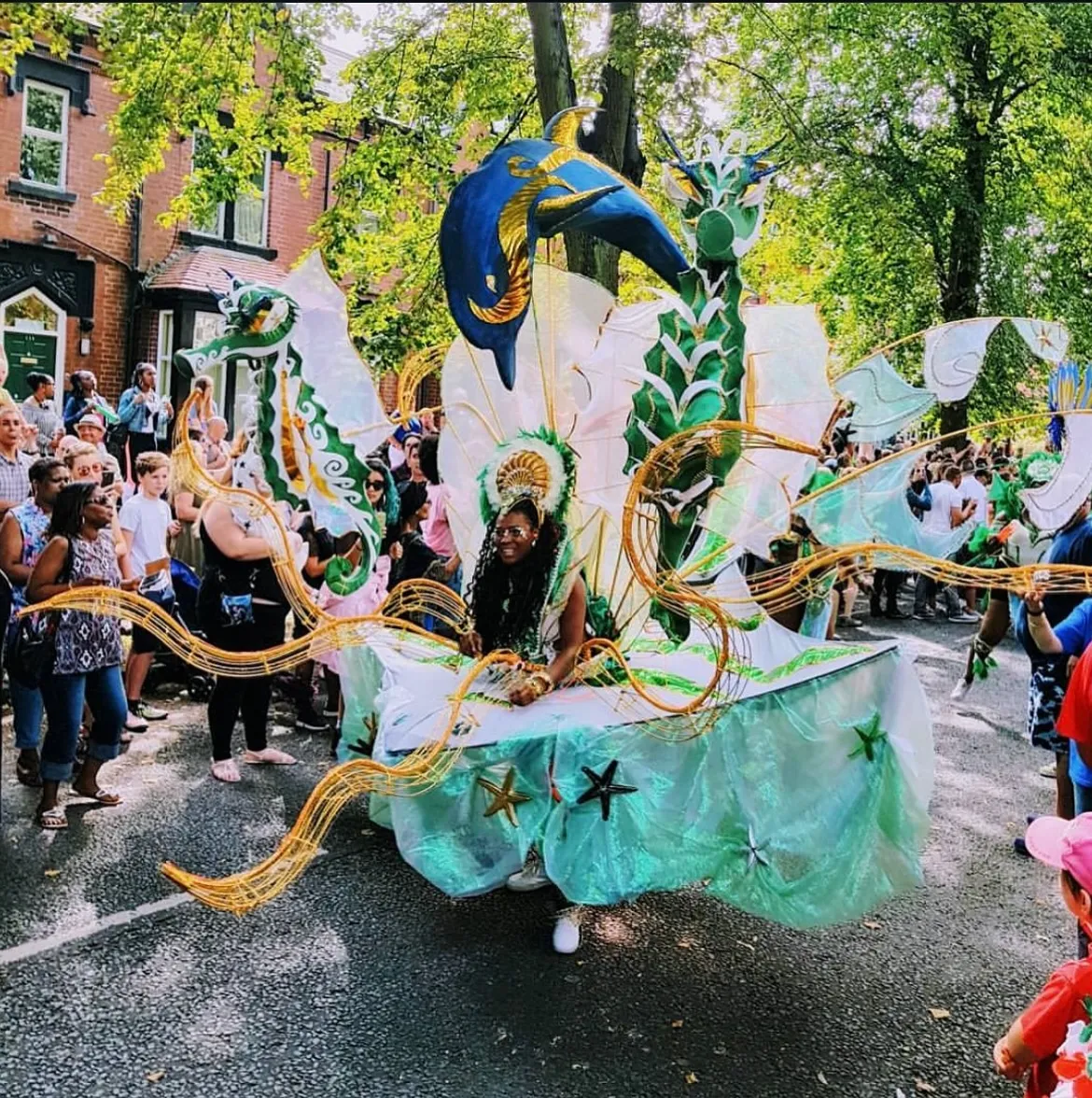 person in the Leeds West Indian Carnival parde in a flamboyant blue and yellow costume