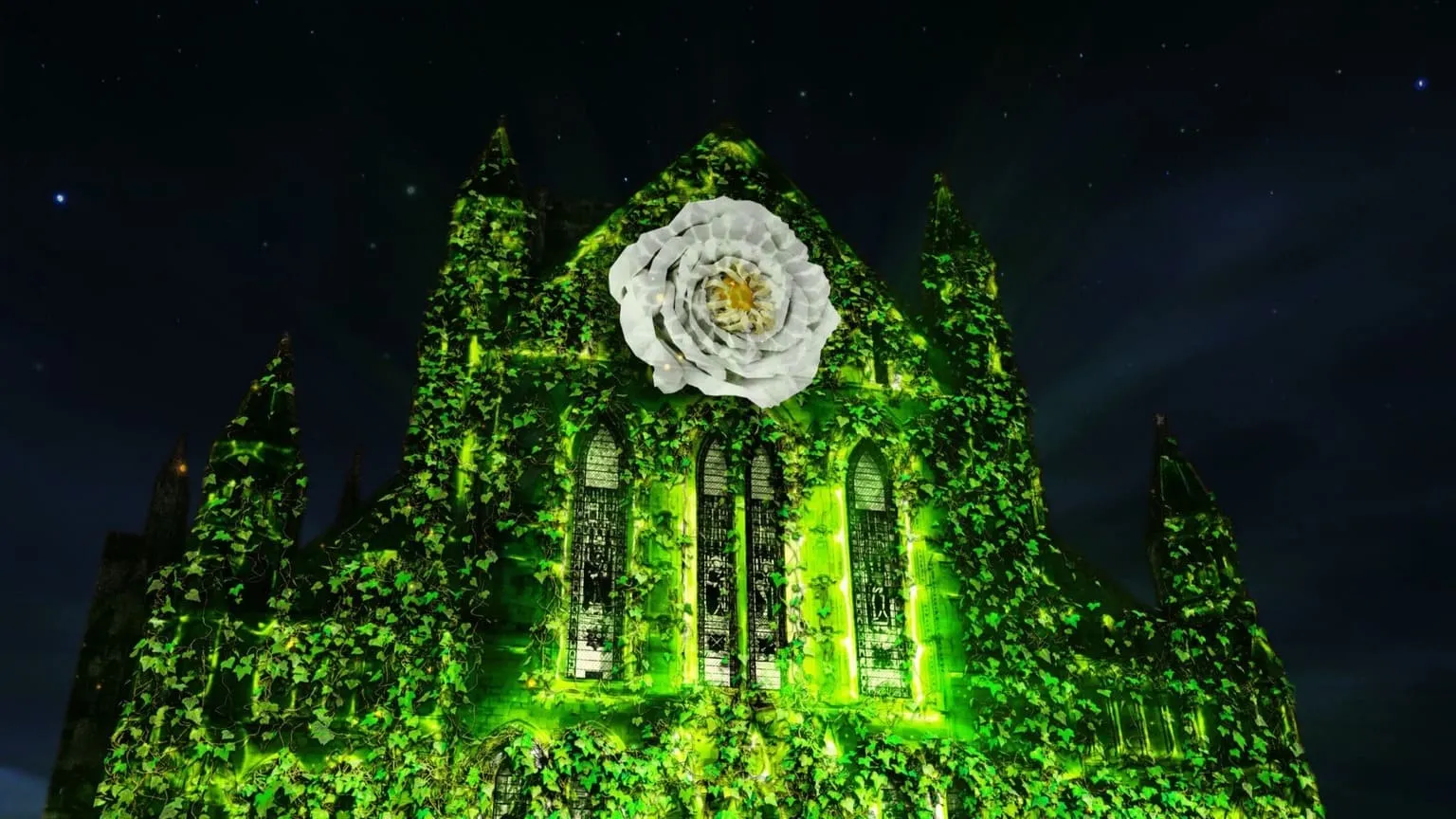 South Trancept of York Minster with a light projection on the building showing green trees and foliage with a white yorkshire rose at the centre.