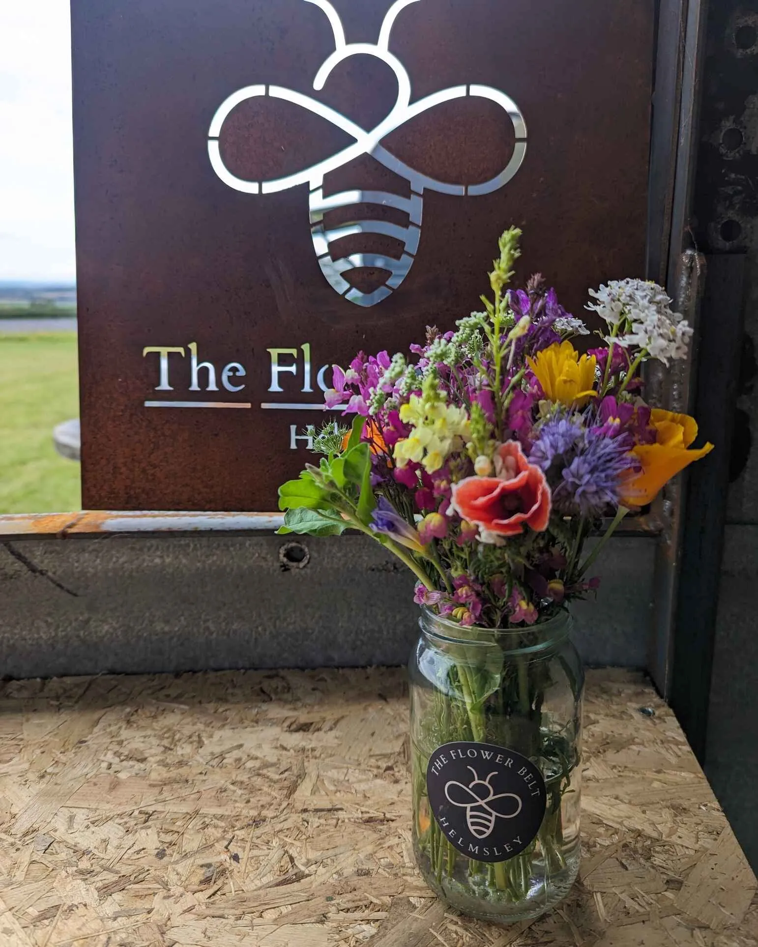 vase of flowers in front of the flower blet sign.