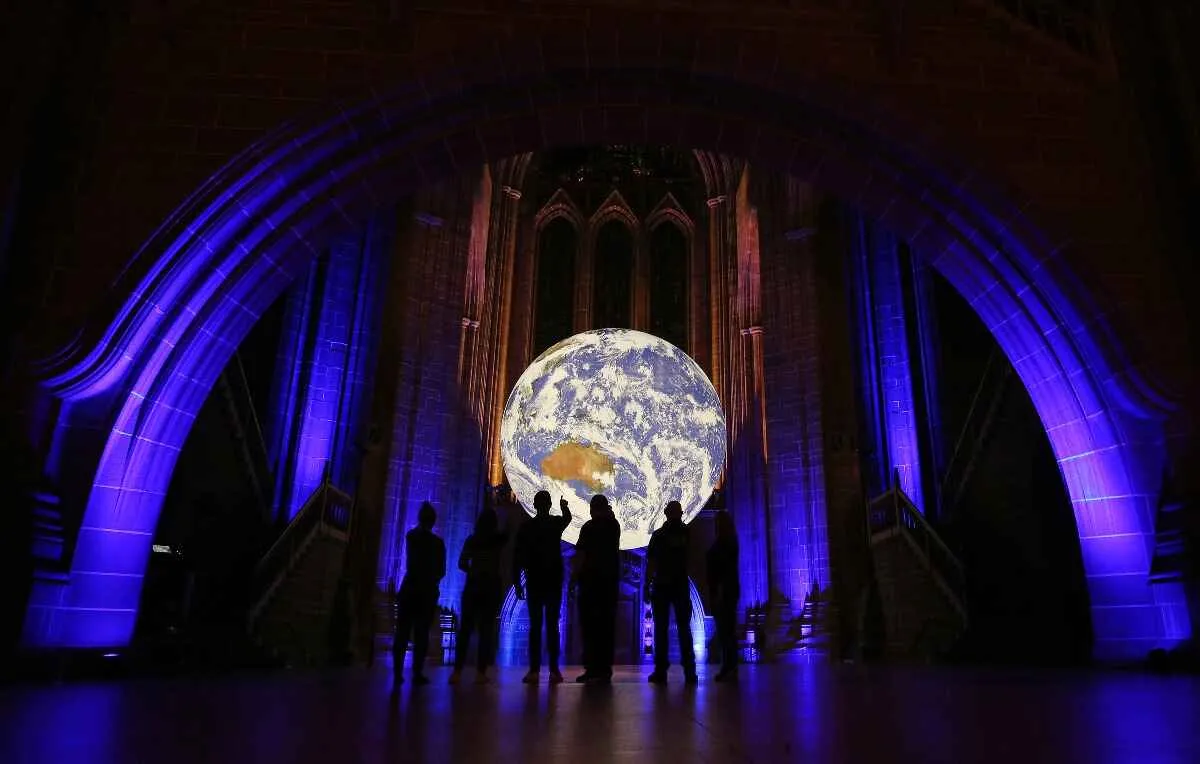 Gaia earth sculpture in a church with people