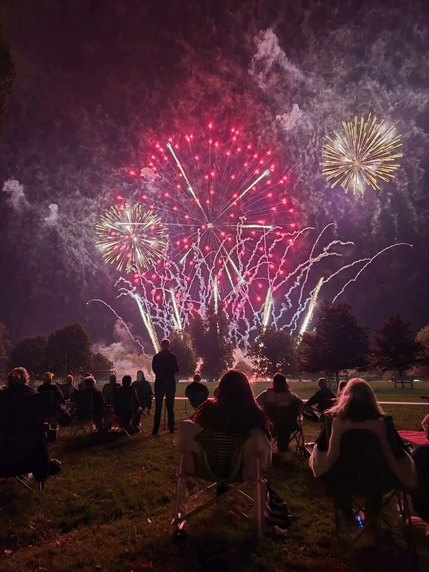 people sitting watching a spectacular firework display.