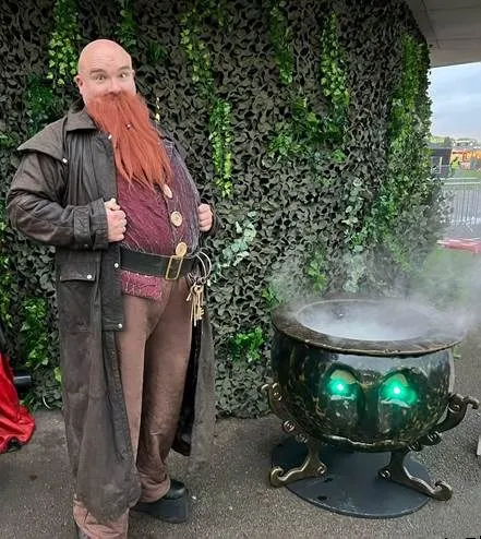 magical fellow standing next to a cauldron