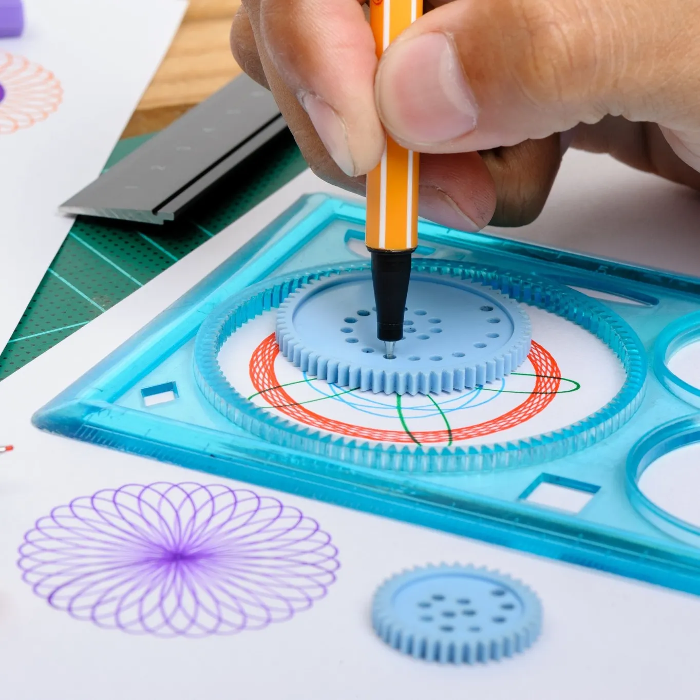 person using a spirograph, close up of hand and the spirograph
