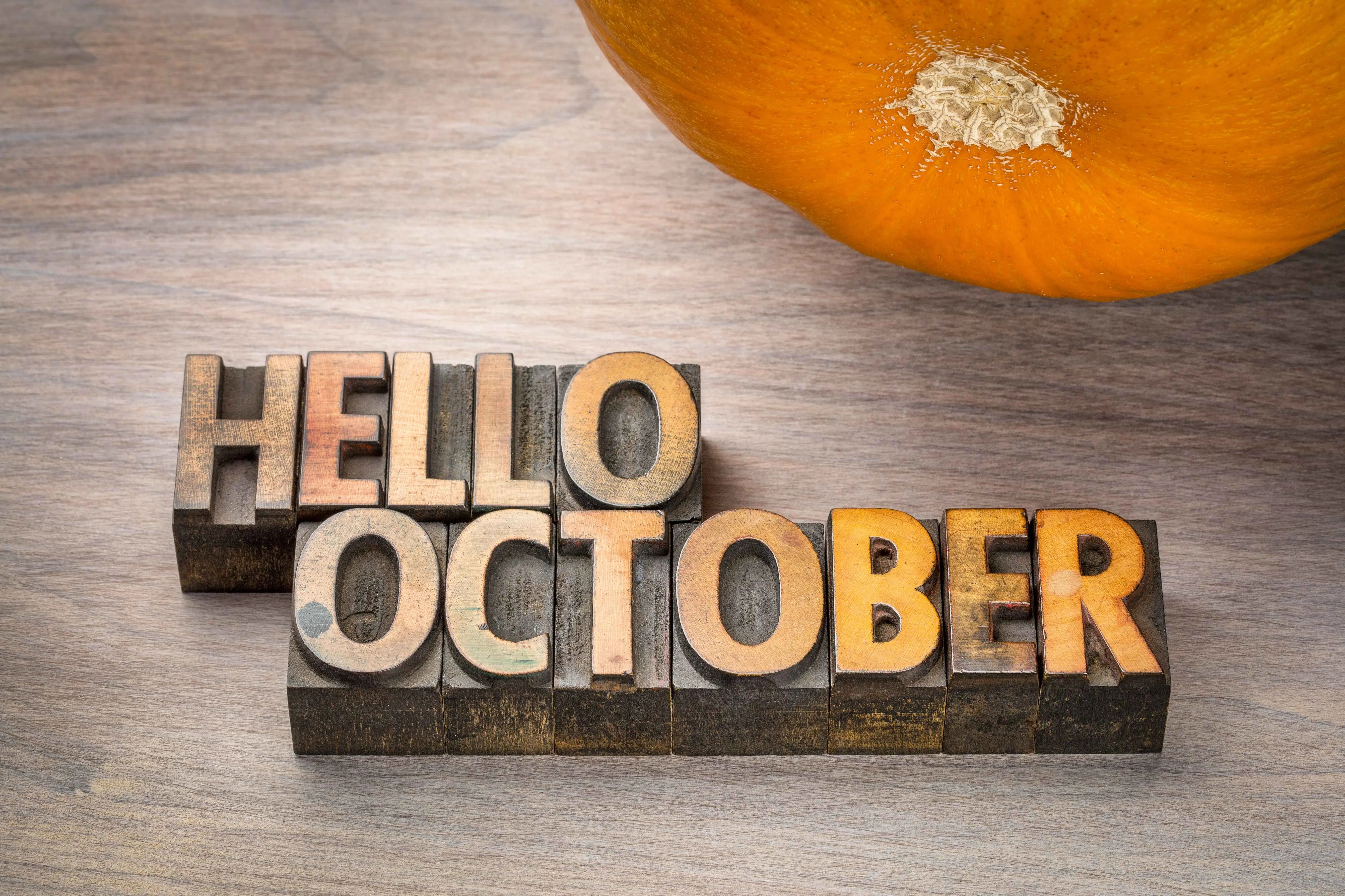 Hello October in block letters with a pumpkin in the corner.