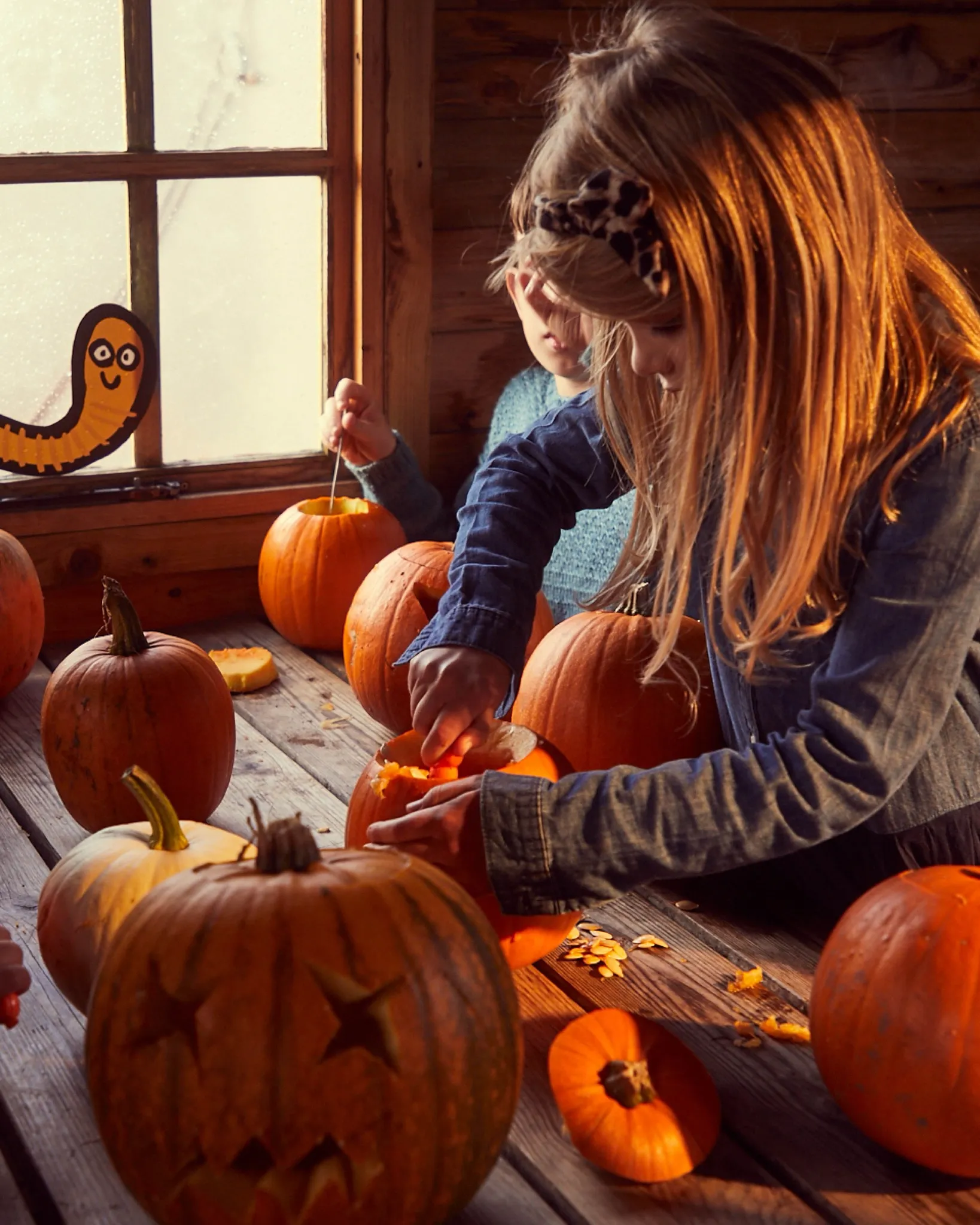 young girl carving a pumpkin