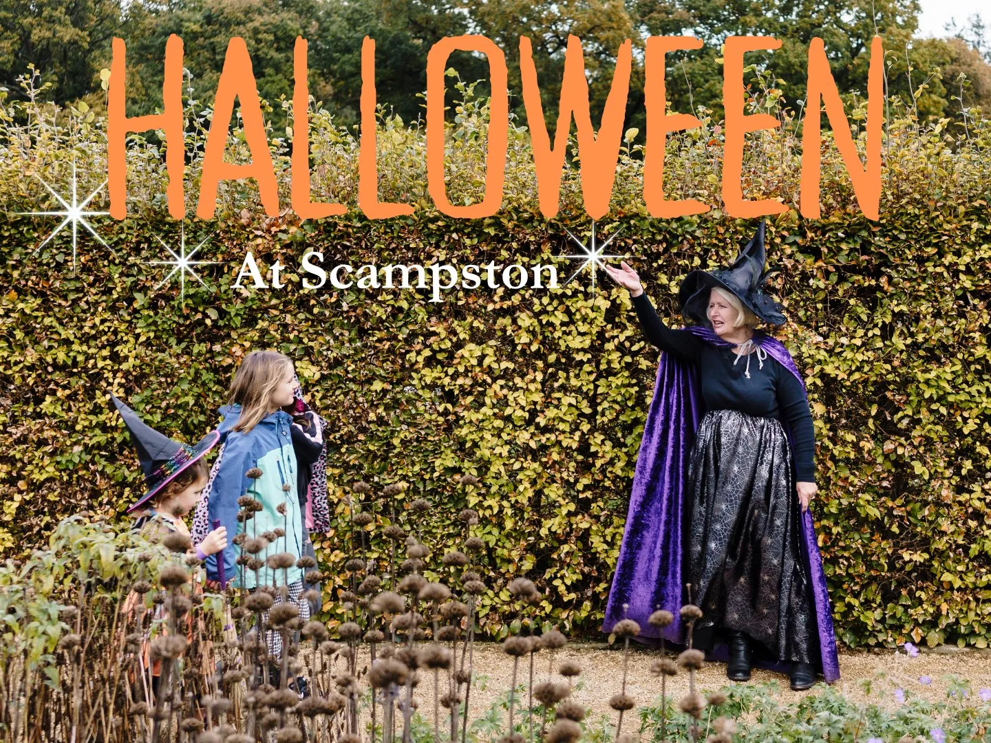 witch next to an autumnal hedge pointing a wand as a small group of children watch