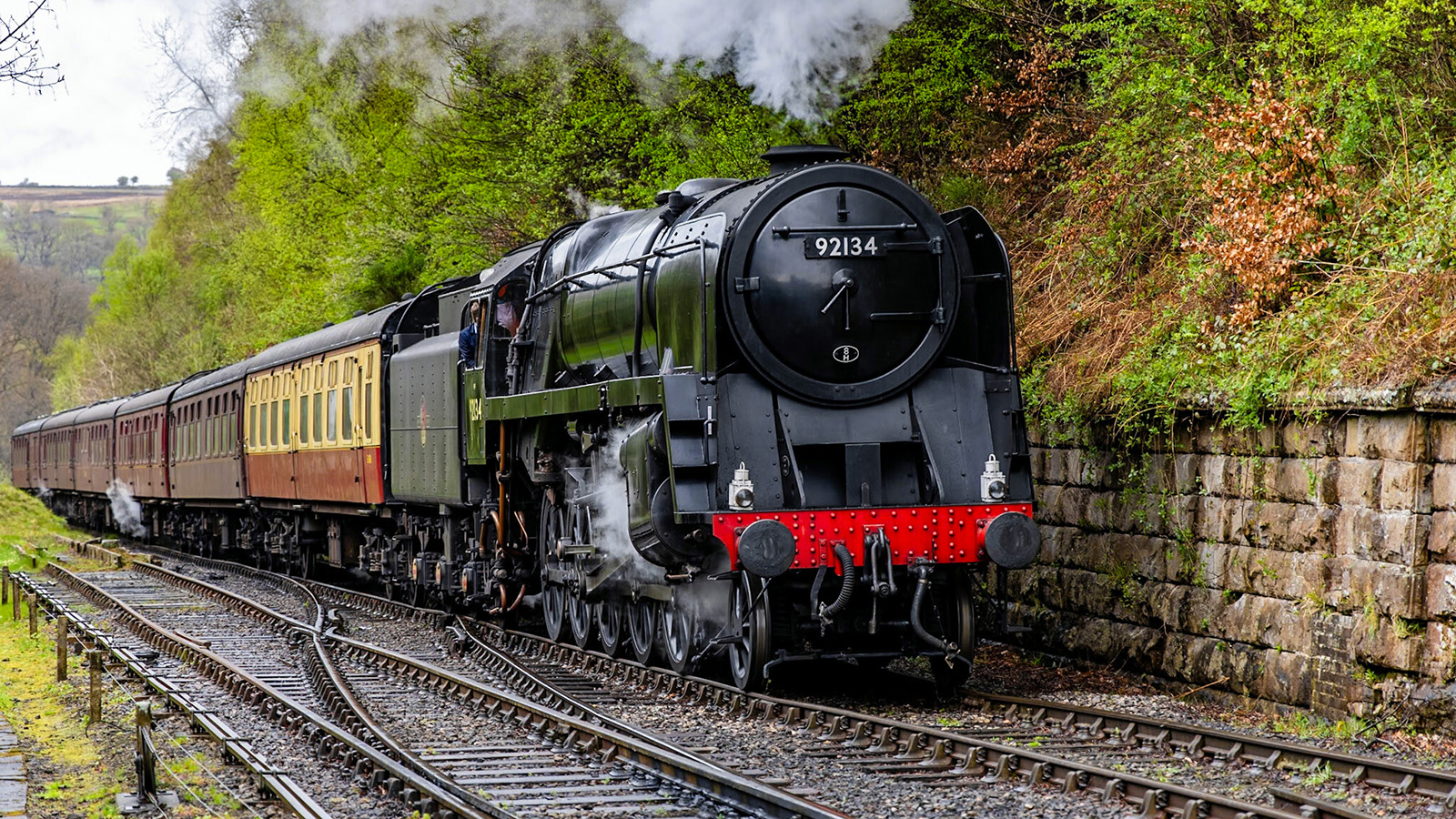 black steam train with carriages behind, photo by Tim Bruce