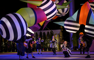 Brightly coloured lamp characters with puppeteers in the street